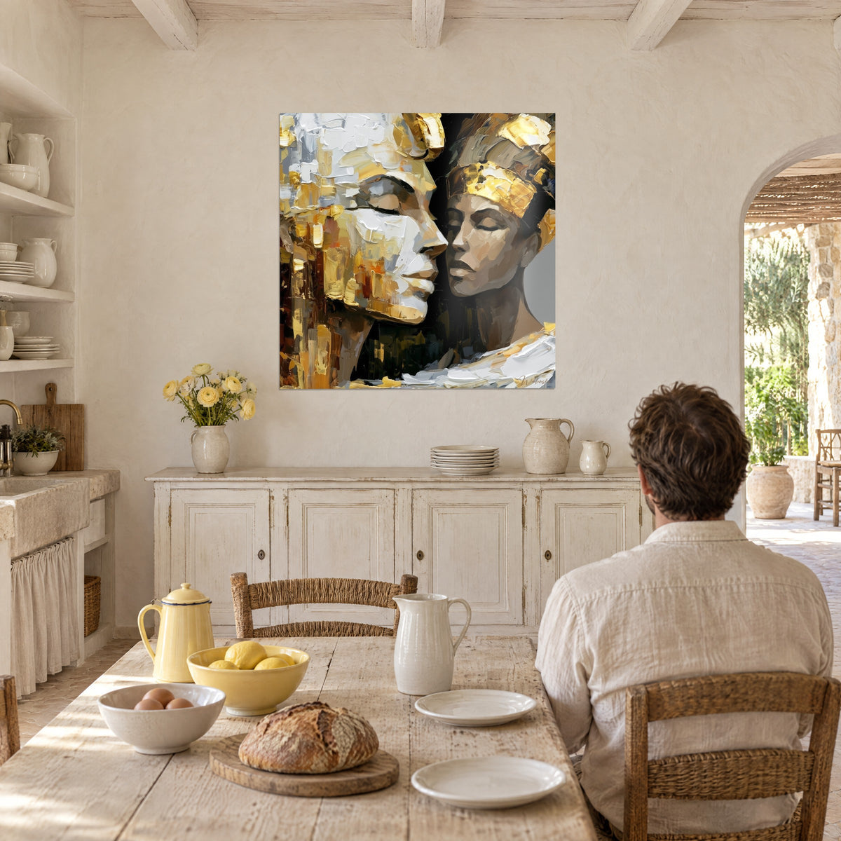 Schilderij gouden heersers voorhoofd tegen voorhoofd, dikke witte en okerkleurige verf op zwarte achtergrond, man van achteren aan tafel, in een eetkamer van een Provençaalse mas