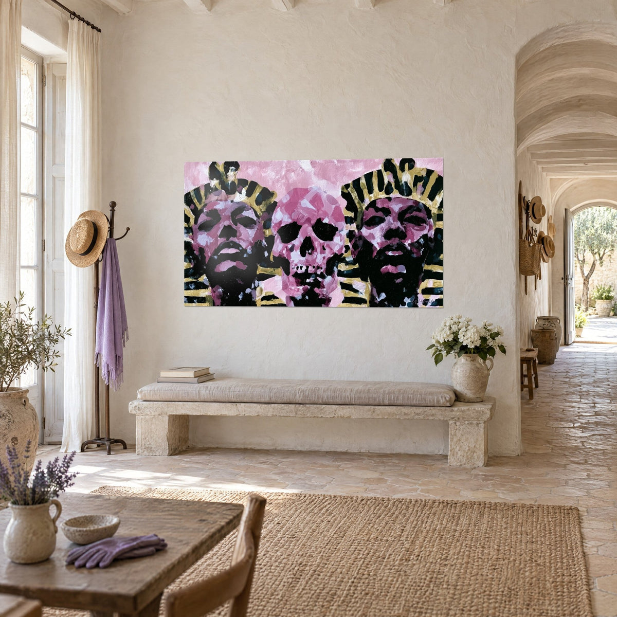 Tableau trio de visages égyptiens rose poudré et noir de jais, crâne central vers l'avant, mur de pierre d'un mas provençal