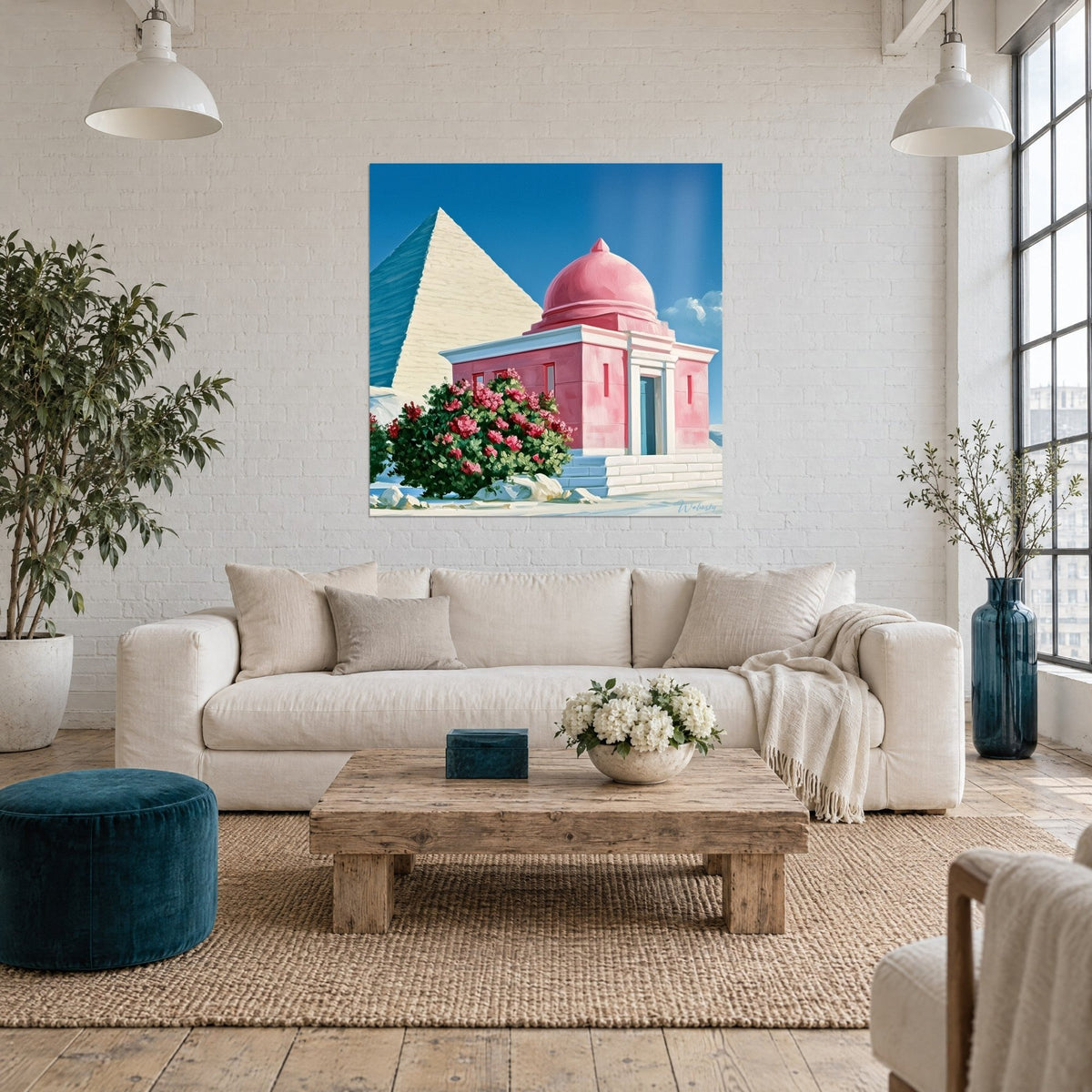 Wall art pink chapel with a dome surrounded by flowering shrubs, cream pyramid and blue sky, above a sofa in a bright living room