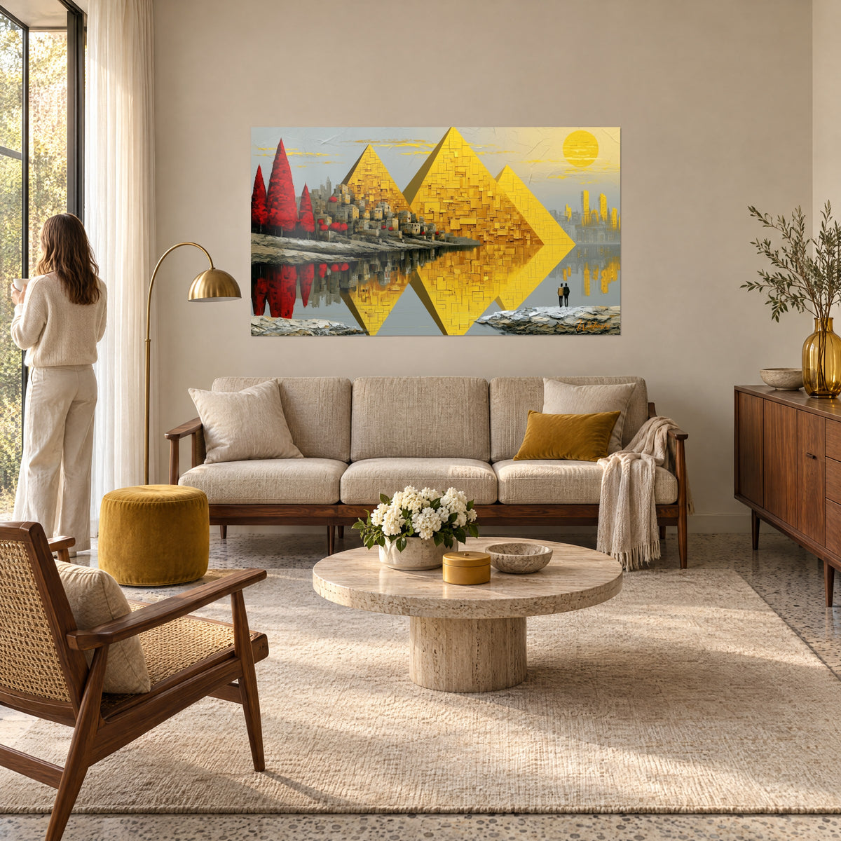Wall art golden pyramids mirrored on grey water, red trees and silhouettes, above a sofa in a bright living room