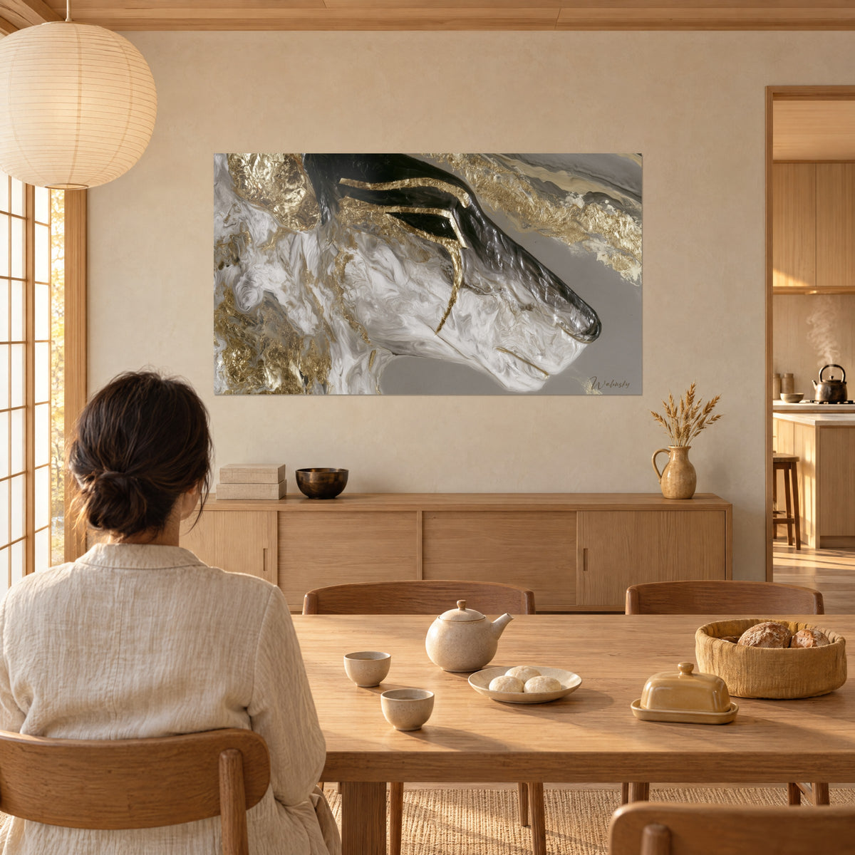 Tableau museau d'antilope en volutes blanches et feuilles d'or martelées, corne anthracite, face à une table en bois blond
