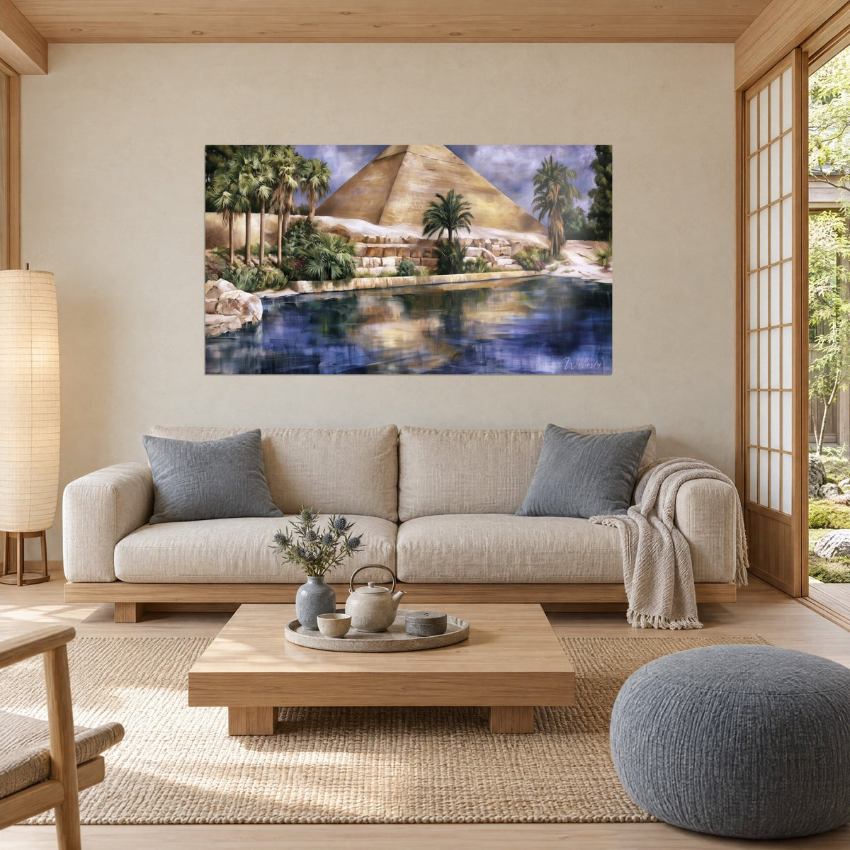 Gemälde mit goldener Pyramide über einer Oase, grüne Palmen und marineblaues Wasser, über einem Sofa in einem hellen Wohnzimmer