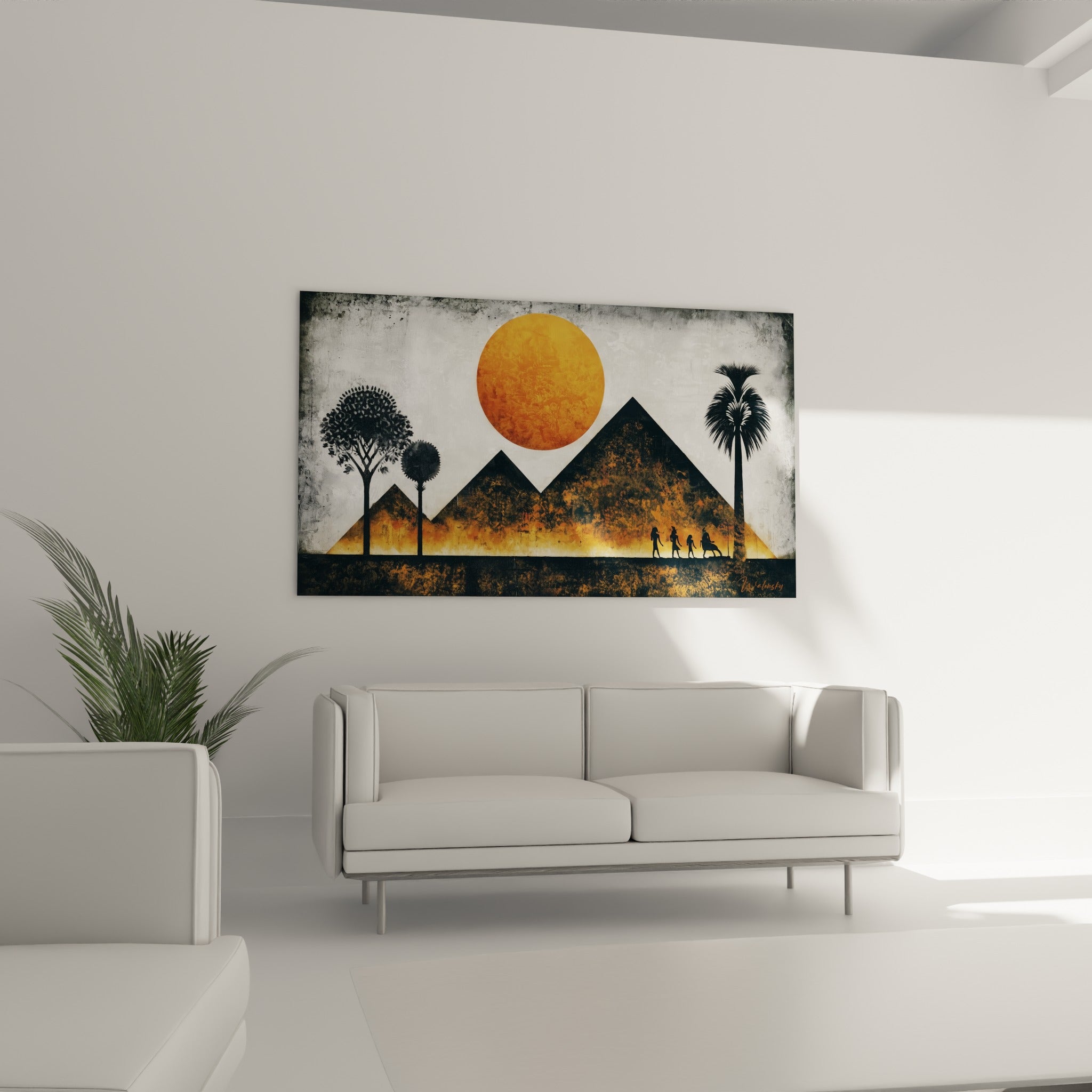 Silhouettes noires marchant devant des pyramides ocre, œuvre suspendue au-dessus d'un canapé dans un salon lumineux