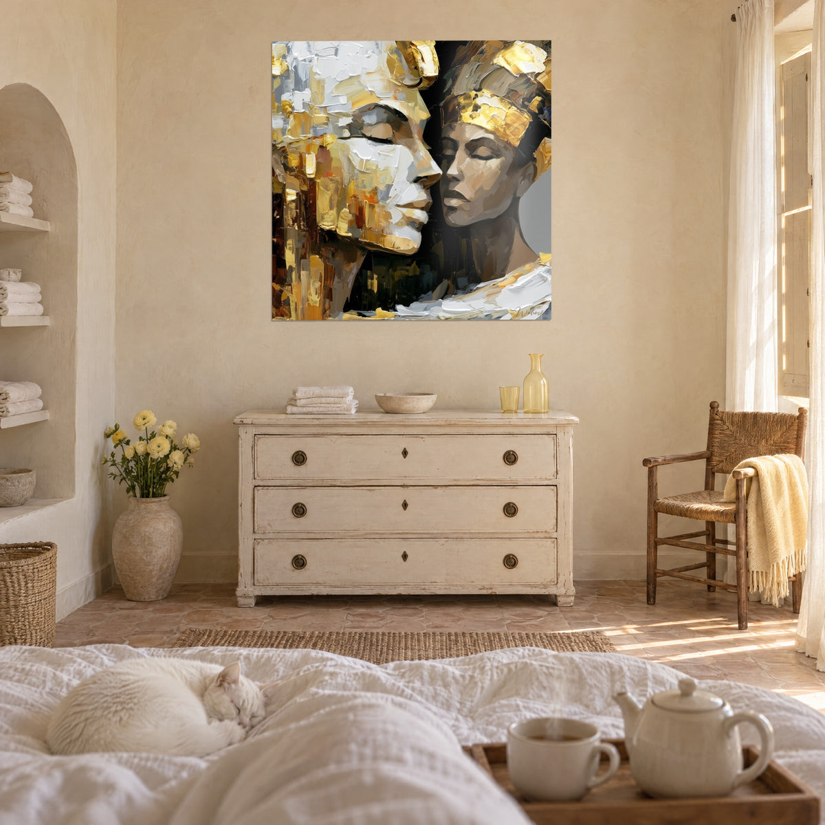 Schilderij koninklijke omhelzing met gouden en ivoren gezichten tegenover elkaar, witte en okerkleurige impasto, liggende witte kat, boven een bed in een lichte slaapkamer