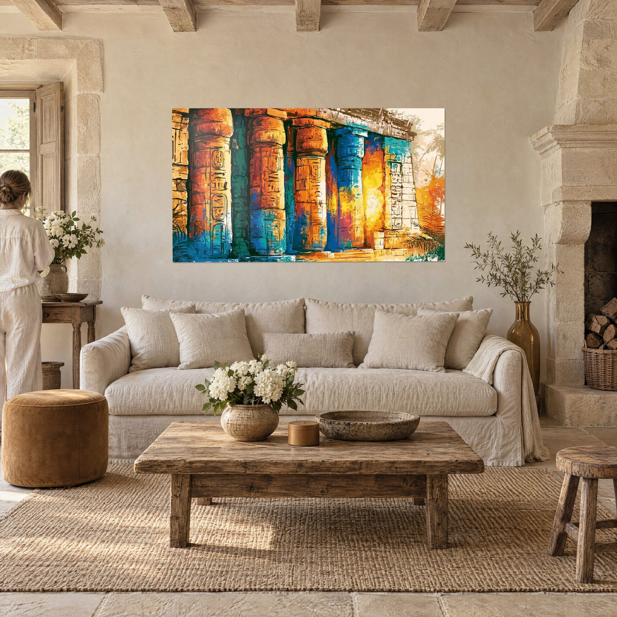 Wall art ochre and turquoise Egyptian temple columns covered in hieroglyphs, a woman seen from behind, above a sofa in a bright living room