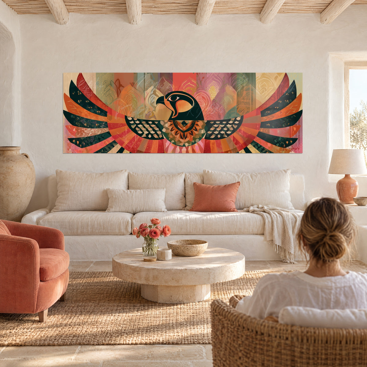 Wall art black Horus falcon with outspread red and orange wings, panoramic piece hung above a sofa in a bright living room