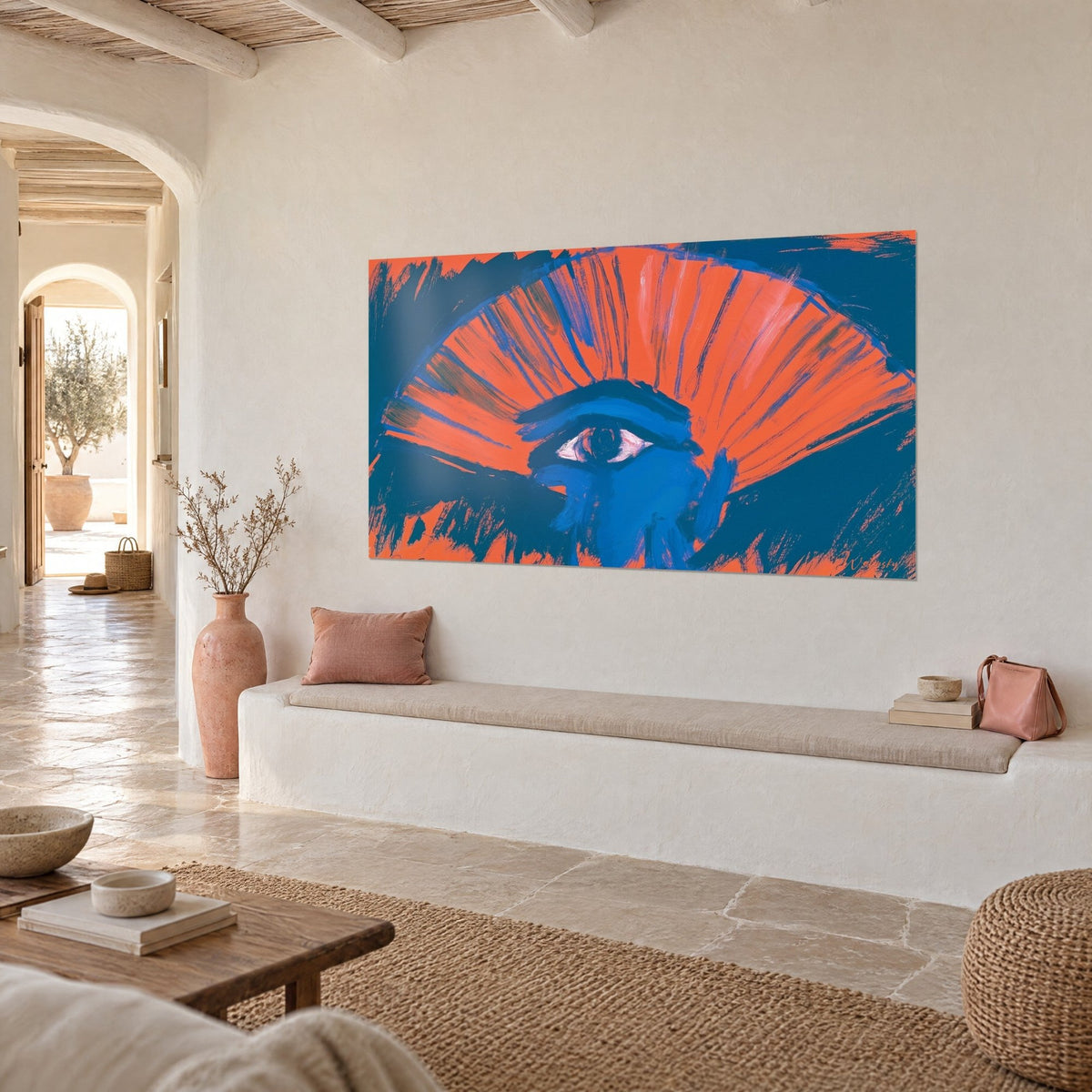 Wall art with a radiant orange fan painted in broad brushstrokes on a midnight blue background, three-quarter view in a living room with a white banquette