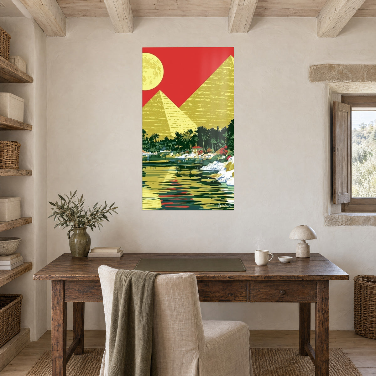 Quadro paesaggio egiziano grafico, piramide giallo vivo, cielo rosso vermiglio, acqua verde scuro, appeso sopra una scrivania in legno