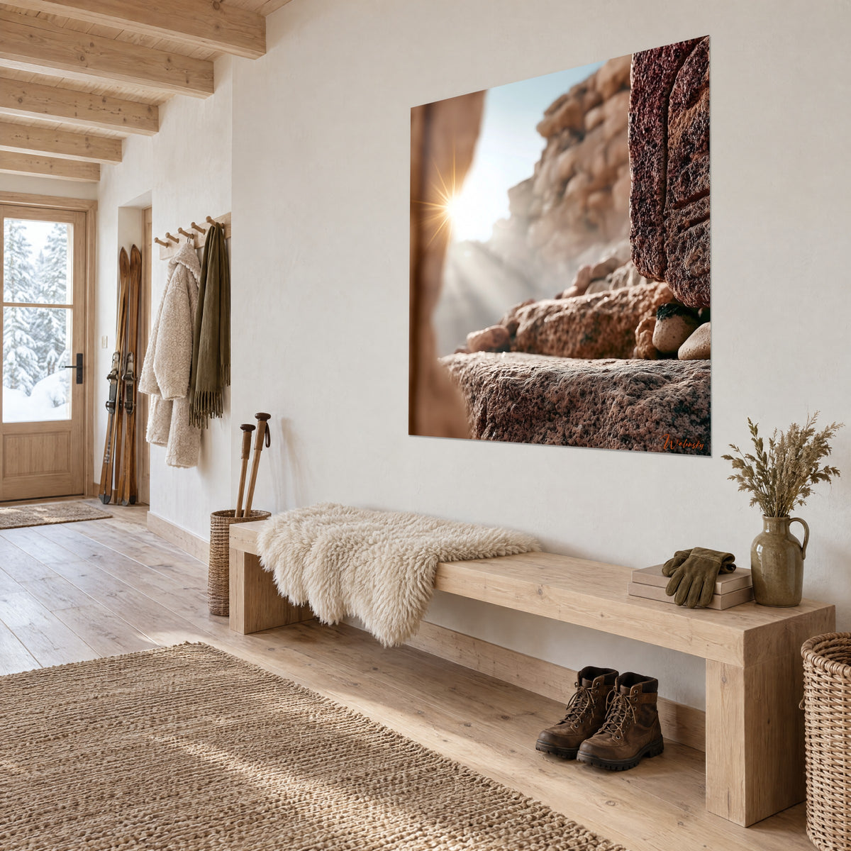 Gemälde einer Sandsteinwand in Rot und Sand, goldene Lichtstrahlen hinter einem körnigen Felsblock, aufgehängt neben dem Eingang eines Holzchalets aus hellem Holz