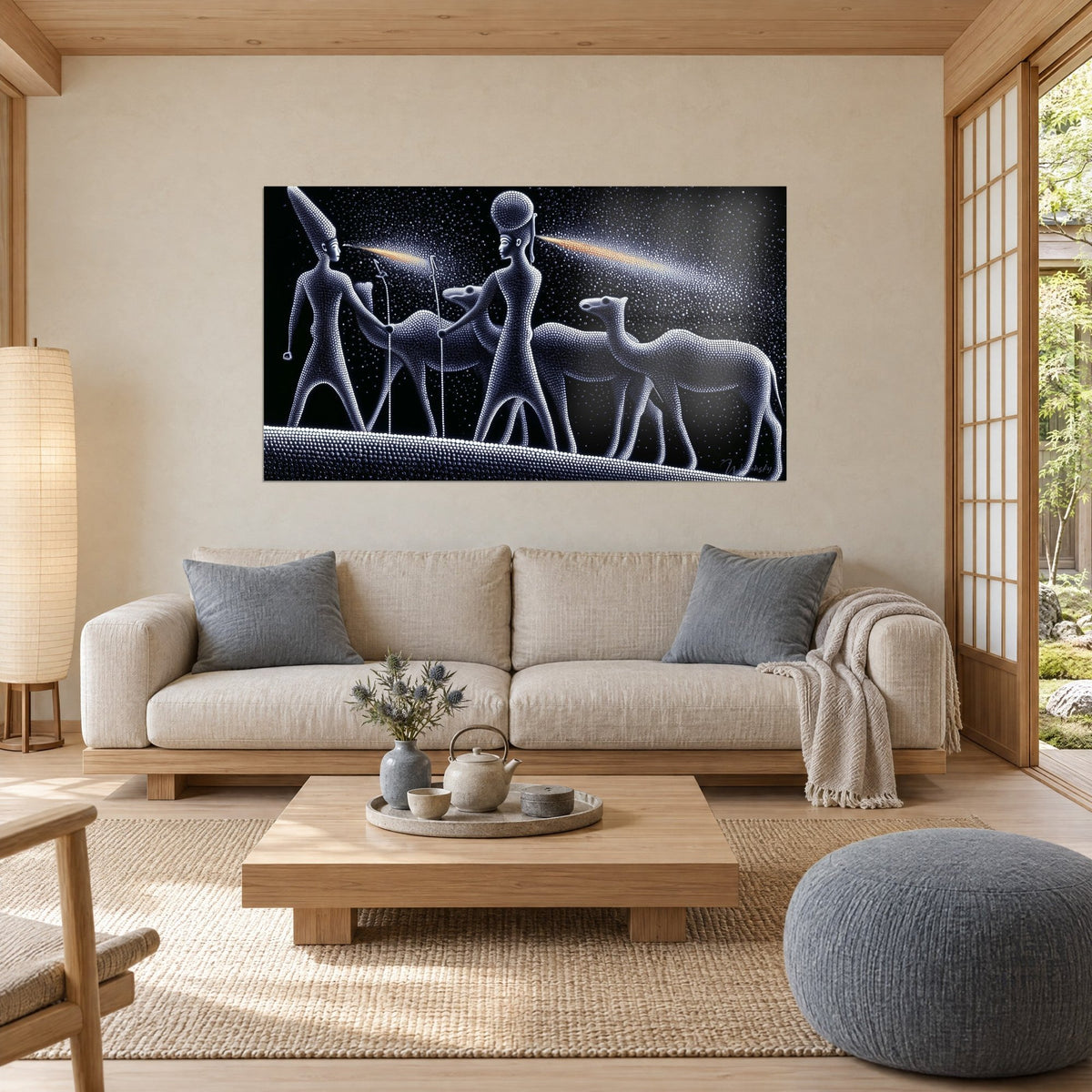 Wall art Egyptian caravan in white beads on black background, two figures and three camels, above a sofa in a bright living room