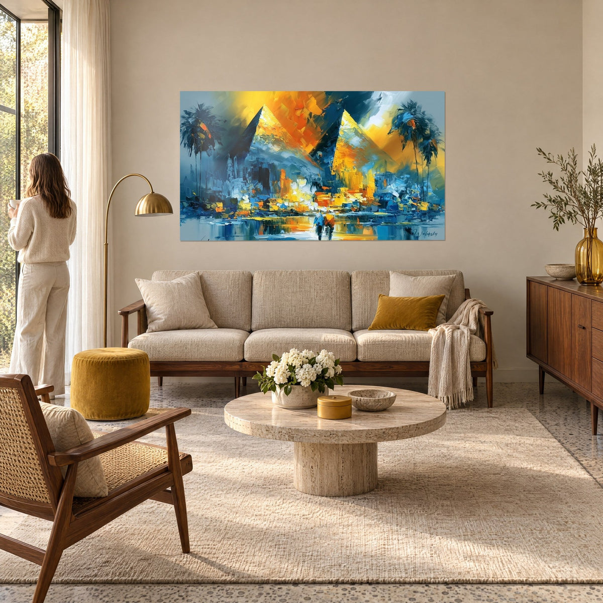 Schilderij twee gouden piramides in paletmesstreken, oranje lucht en nachtblauwe palmbomen, boven een bank in een lichte woonkamer