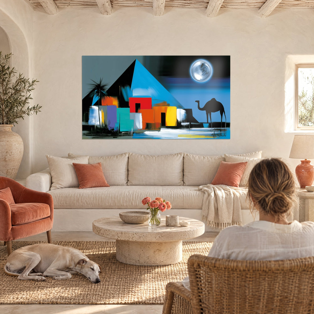 Cuadro de pirámide azul eléctrico bajo una luna plateada, casas rojas y amarillas, encima de un sofá en un salón luminoso