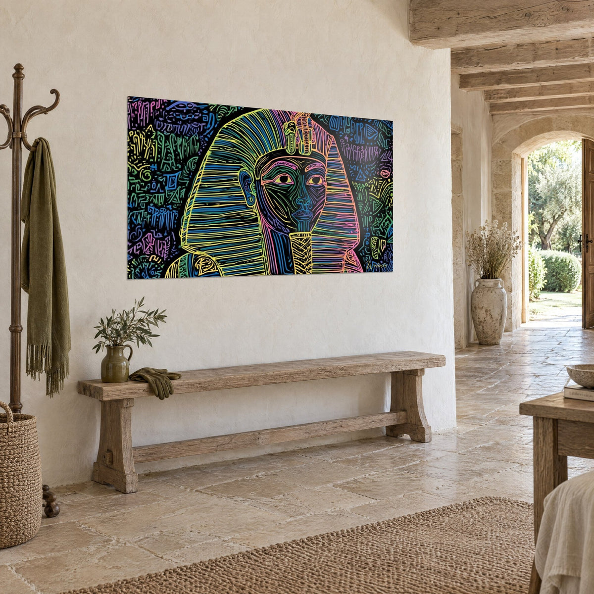 Wall art Egyptian mask with pink and green neon arabesques on black background, hung above a bench, stone house