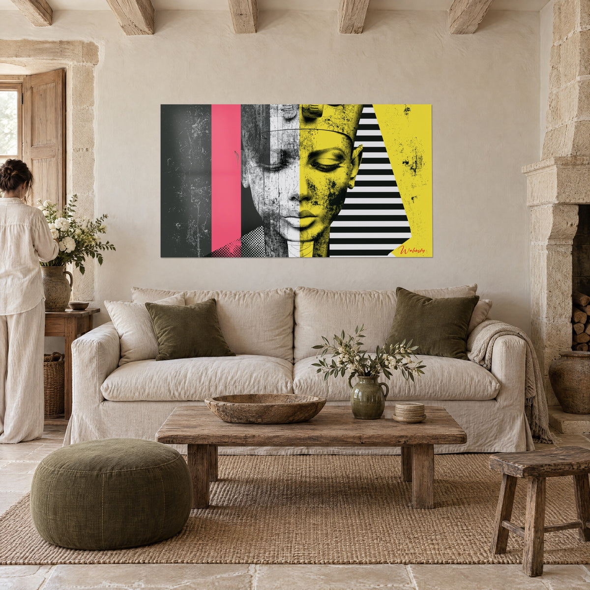 Cuadro busto de faraón, mitad gris y mitad amarillo limón, bandas rosa vivo y negras, encima de un sofá en un salón luminoso