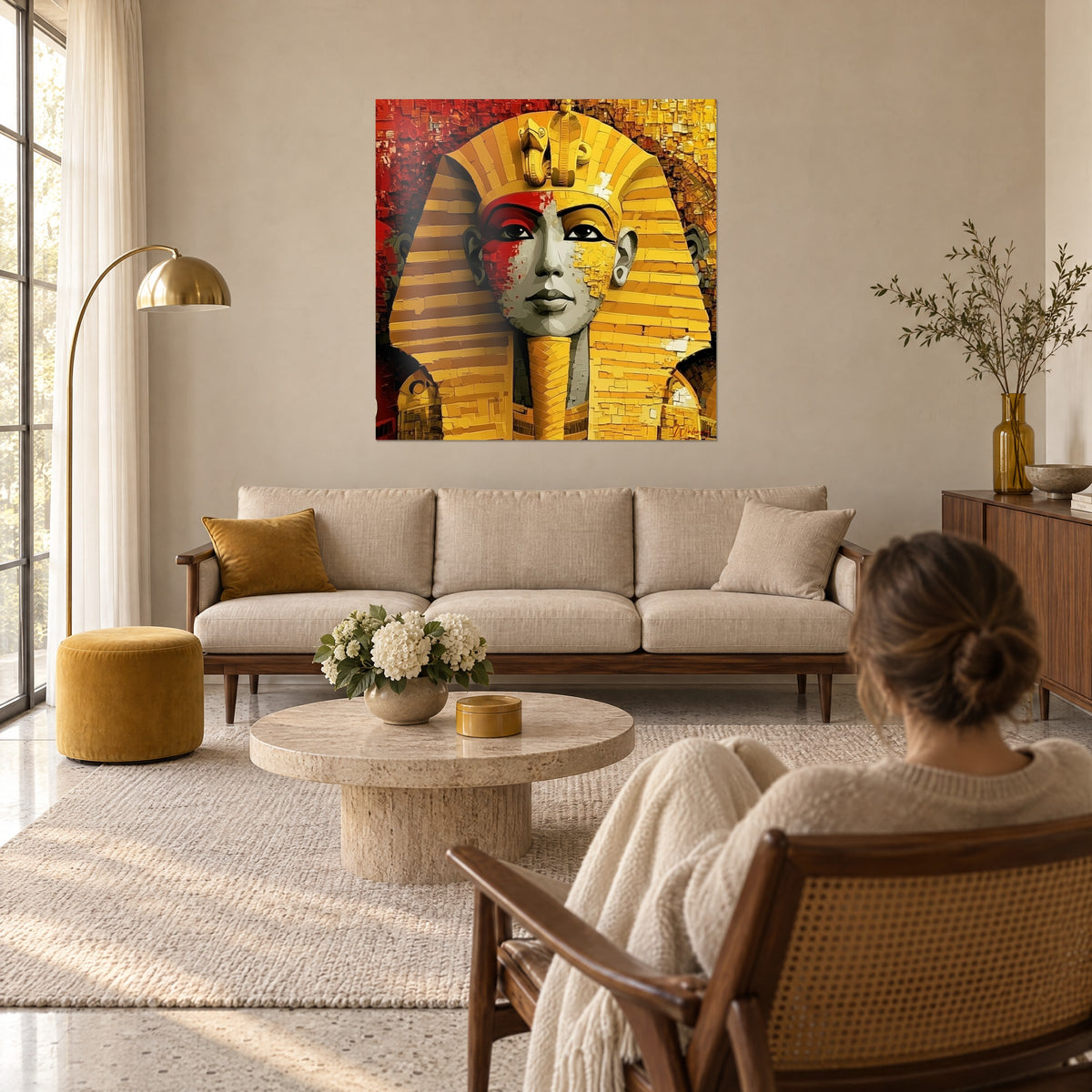 Schilderij farao met nemes gestreept in goud en rood, frontale cobra in reliëf, grijs gezicht, boven een bank in een lichte woonkamer
