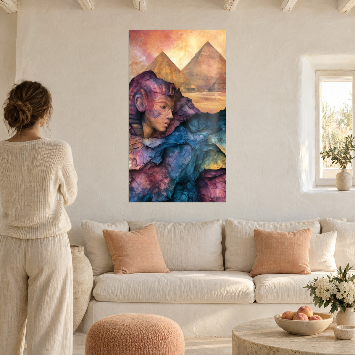 Gemälde Sphinx in Violett und Blau mit zerknittertem Papier vor goldenen Pyramiden, Frau von hinten, über einem Sofa in einem hellen Wohnzimmer