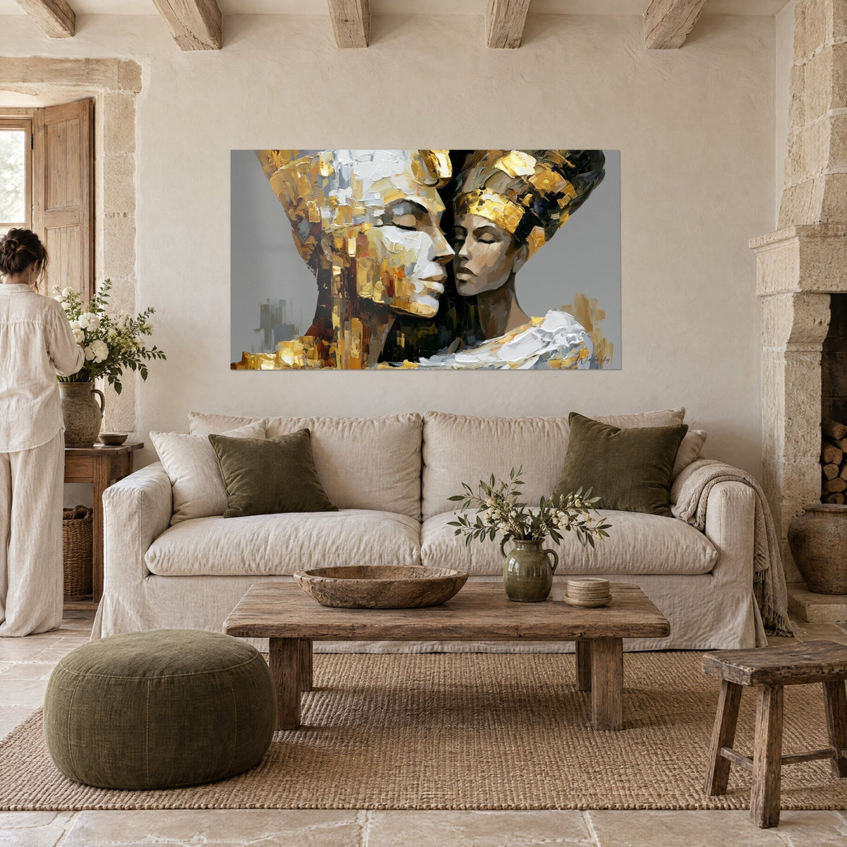 Wall art two Egyptian queens forehead to forehead, gold and white palette knife strokes on grey, above a sofa in a bright living room