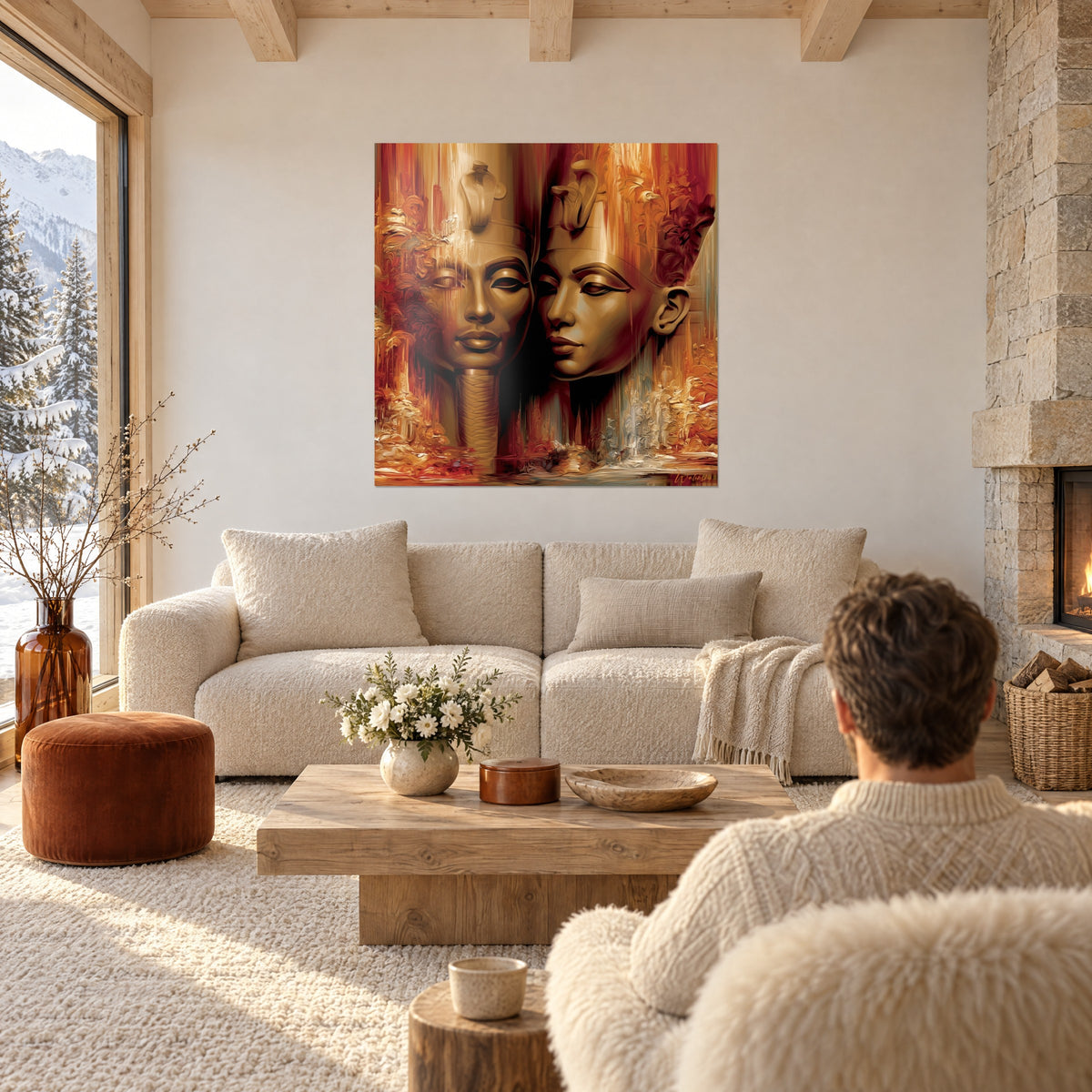 Quadro di due volti faraonici in oro e bordeaux, cobra reale sulla fronte, colature ocra, sopra un divano in un soggiorno luminoso