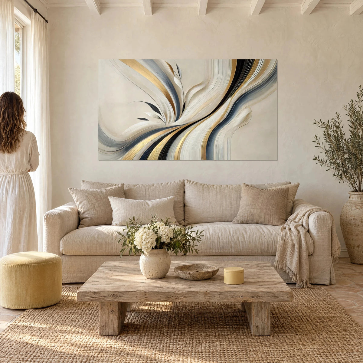 Gemälde mit Bündel geschwungener Linien in Gold, Grau und Schwarz auf cremefarbenem Grund, zwei Personen von hinten, über einem Sofa in einem hellen Wohnzimmer