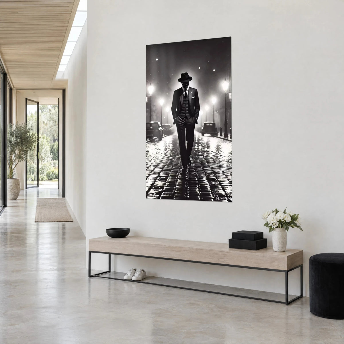 Quadro di un gentiluomo con cappello nero di feltro, mani in tasca, lampioni bianchi in alone, parete chiara di un ingresso in tre quarti