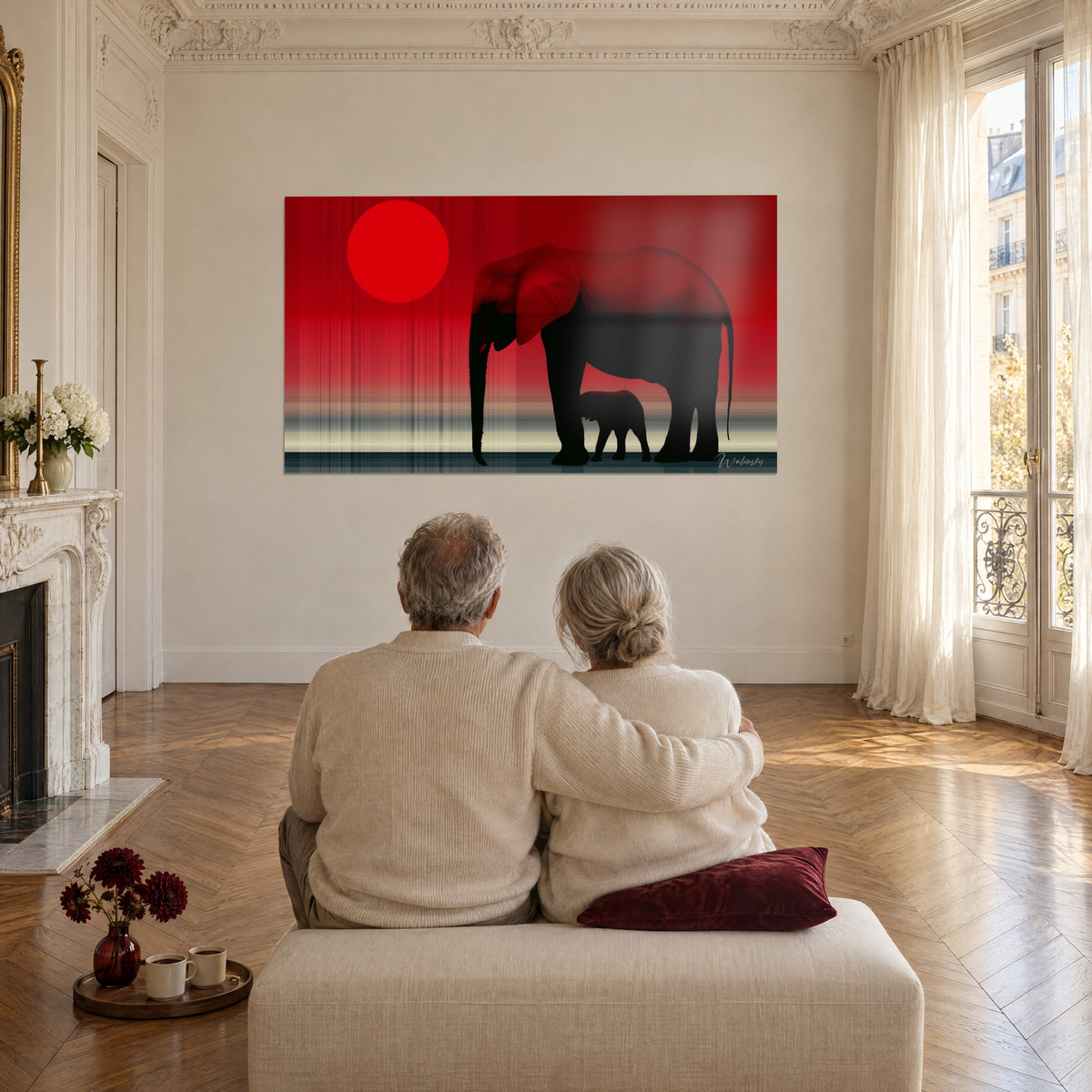 Wall art lowered trunk of a large black elephant on a red and cream sky, couple embracing from behind on a beige pouf, Haussmann-style salon