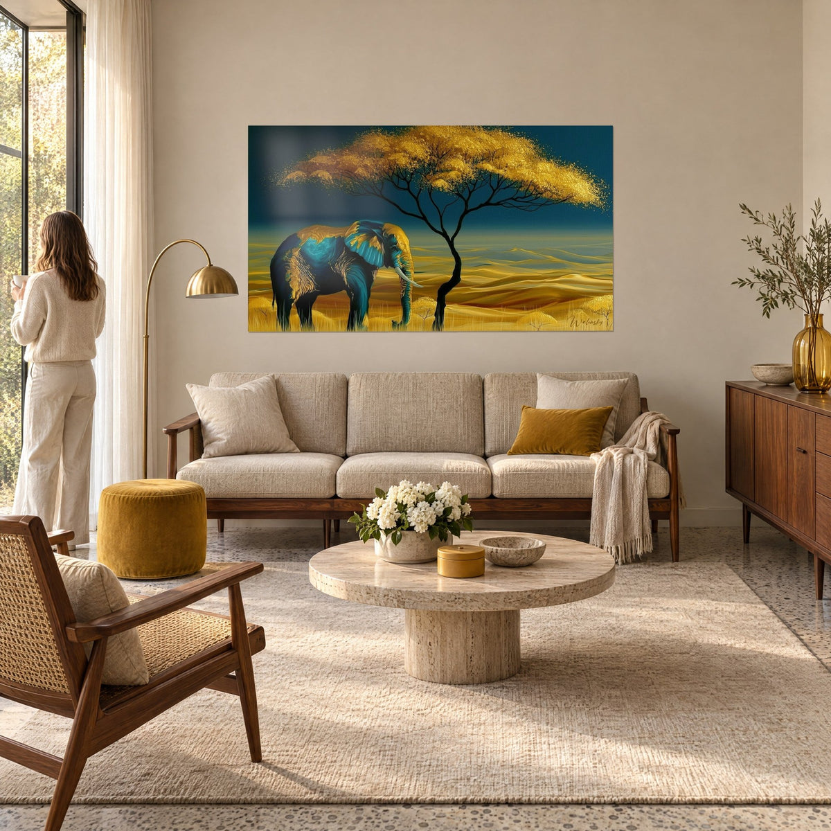 Gemälde eines Elefanten in Petrolblau mit goldenen Adern unter einer goldenen Akazie, Frau von hinten, über einem Sofa in einem hellen Wohnzimmer