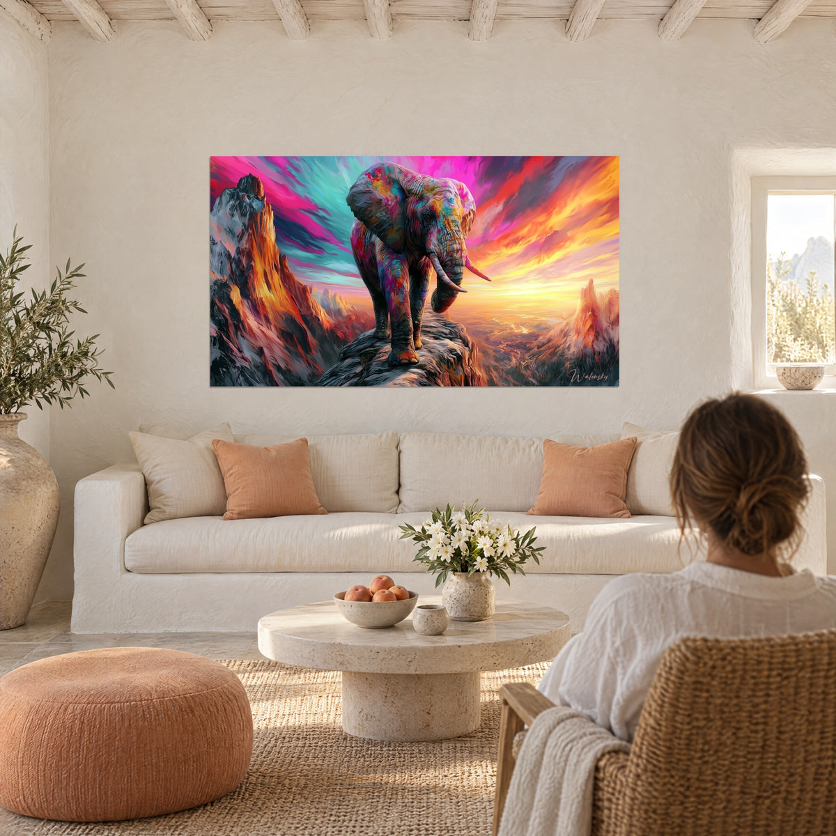 Quadro di elefante con fianchi rosa e turchese su una roccia, cielo arancione in fiamme, sopra un divano in un soggiorno luminoso