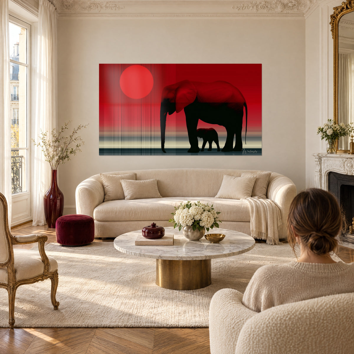 Wall art elephant mother and calf in black silhouette under a red sun, cream walls, above a sofa in a bright living room