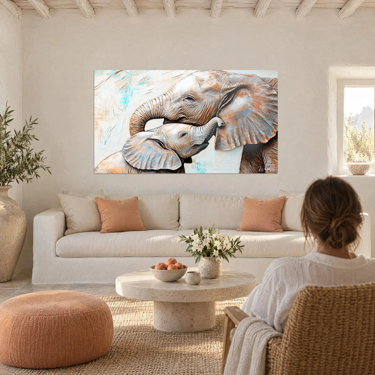 Gemälde Elefantenbaby, eng an seine Mutter geschmiegt, Rüssel ineinander verschlungen, Ocker und Türkis, über einem Sofa in einem hellen Wohnzimmer