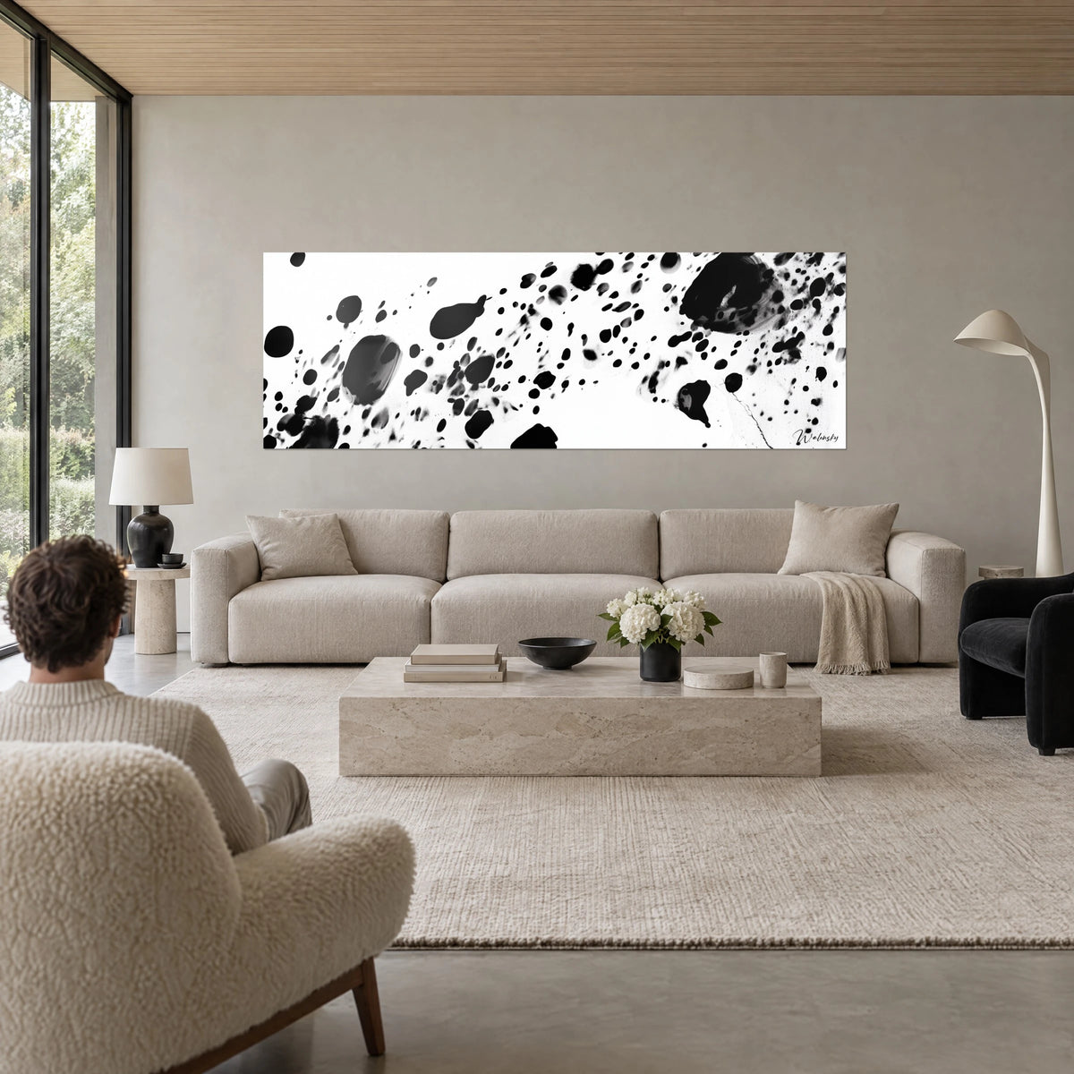 Quadro di schizzi di inchiostro nero su fondo bianco, grande macchia ovale a destra, sopra un divano in un soggiorno luminoso