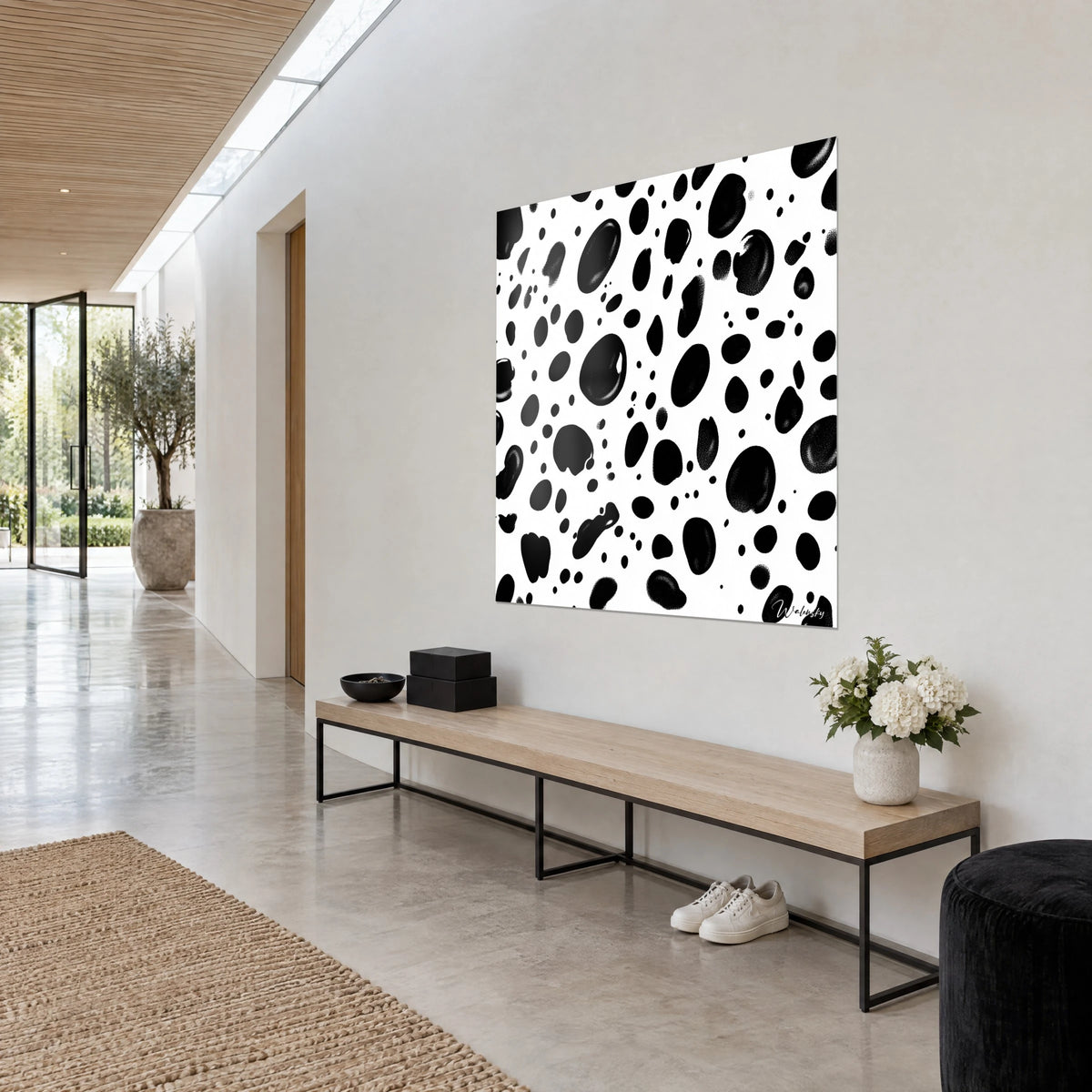 Cuadro con motivo moteado en tinta negra sobre blanco puro, gotas ovaladas y puntos dispersos, en la pared de un pasillo de arquitecto