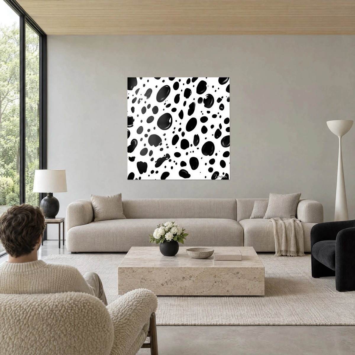 Gemälde mit schwarzen Leopardenflecken auf weißem Grund, glänzende ovale Tupfen mit Lichtreflexen, über einem Sofa in einem hellen Wohnzimmer