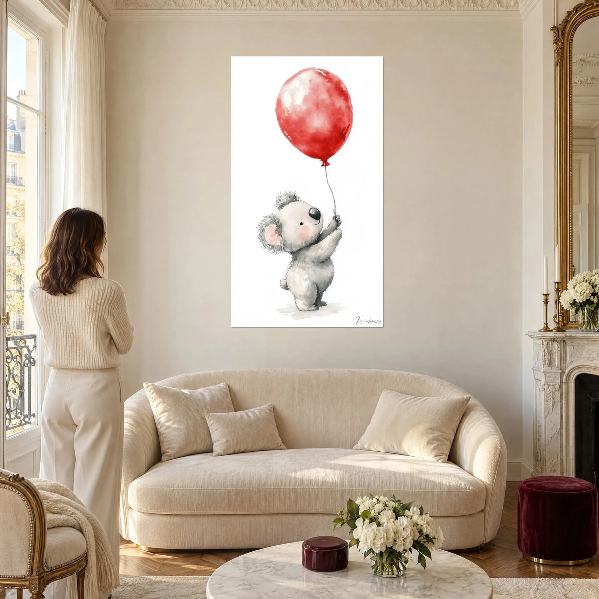 Gemälde junger grauer Koala, der die Pfote nach einem glänzenden roten Ballon ausstreckt, Aquarell auf weißem Grund, über einem Sofa in einem hellen Wohnzimmer