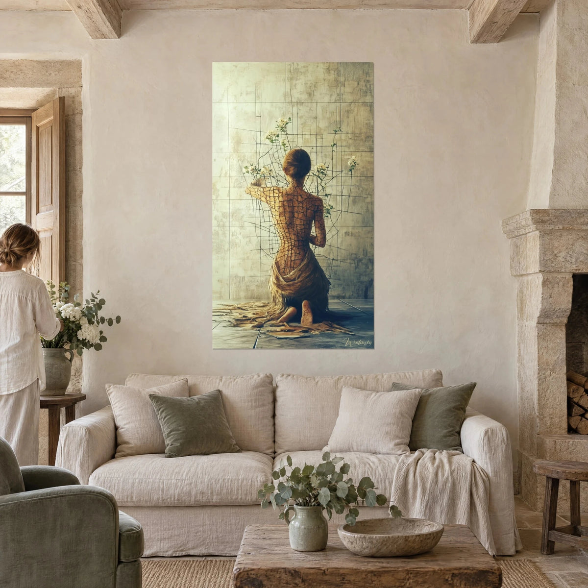 Wall art of a kneeling woman with a cracked back, white flowers and a cracked beige wall, above a sofa in a bright living room