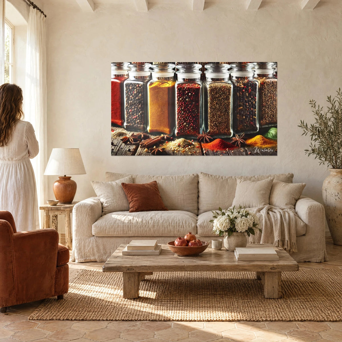 Schilderij van op een rij geplaatste glazen kruidenpotjes, zwarte peper, gele kurkuma en rode chili, boven een bank in een lichte woonkamer