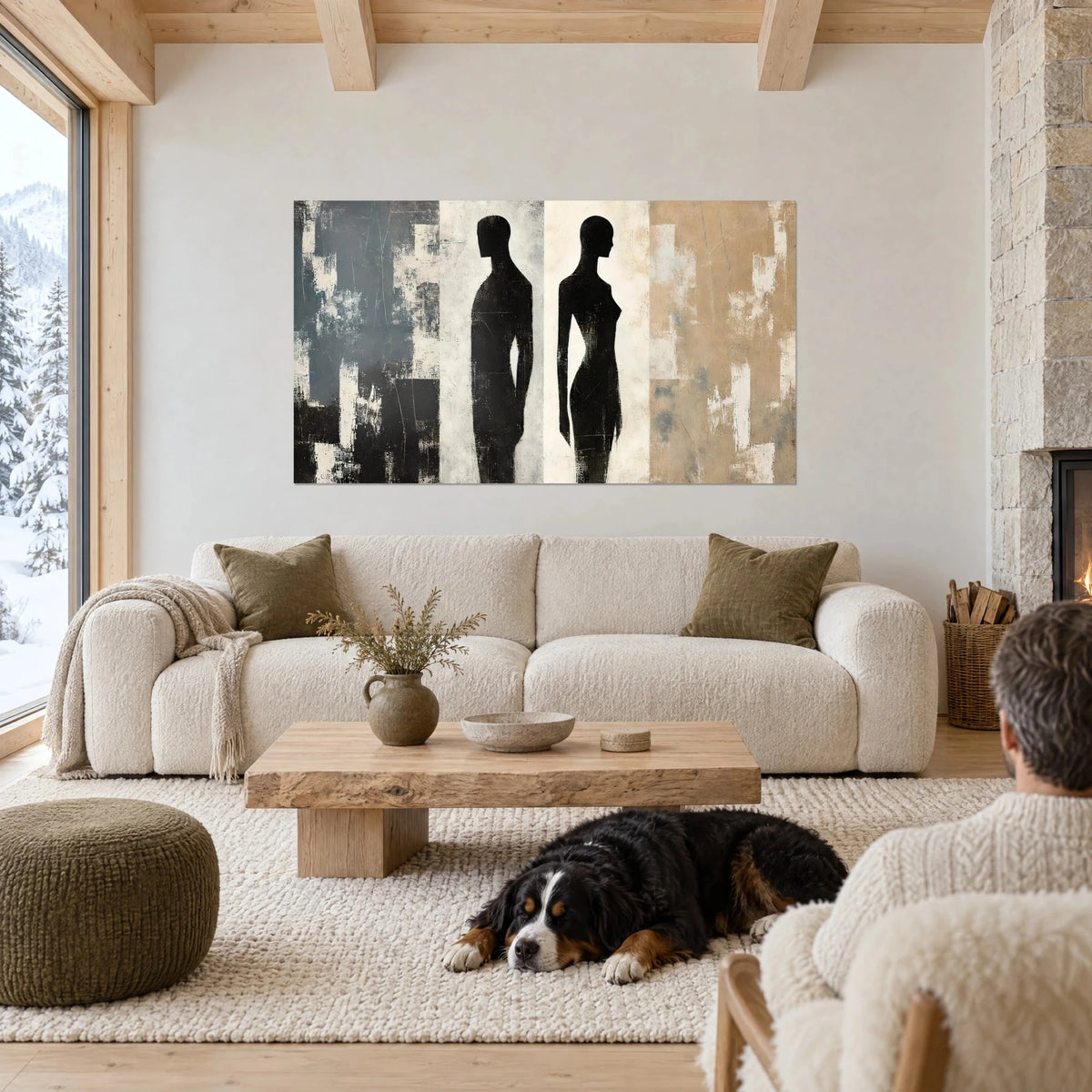 Gemälde mit zwei schwarzen Silhouetten Rücken an Rücken, schiefergrauer, cremefarbener und sandfarbener Hintergrund, liegender Hund, über einem Sofa in einem hellen Wohnzimmer