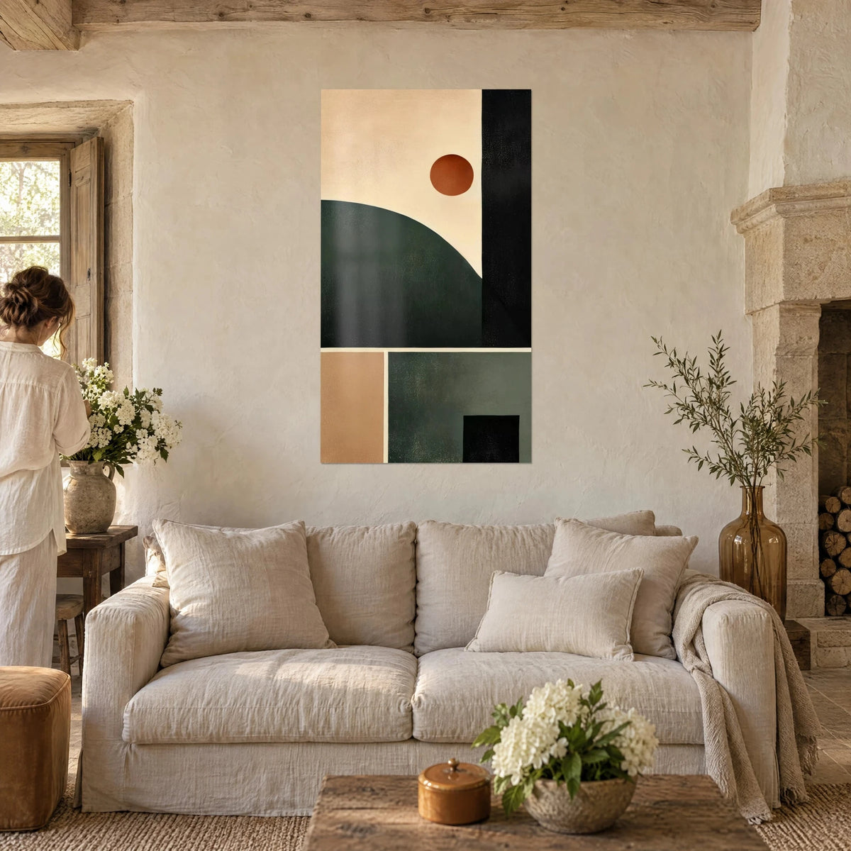 Wall art with cubist composition, rust-colored sun over a fir-green hill and black band, above a sofa in a bright living room