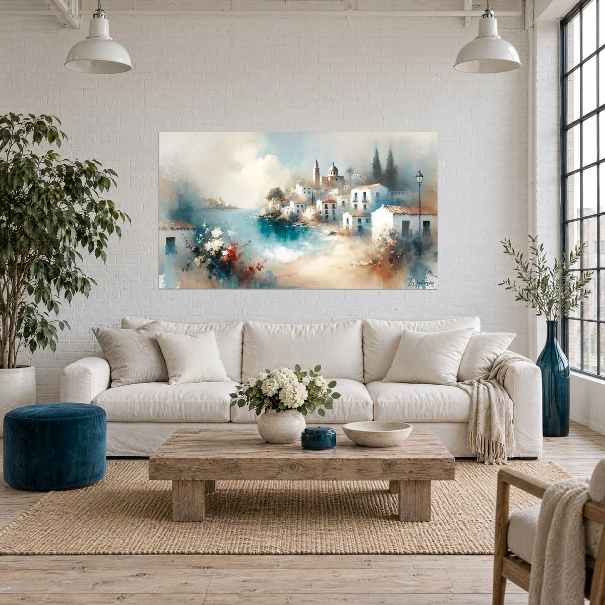 Tableau village blanc andalou au bord d'une baie turquoise, bouquet rouge au premier plan, au-dessus d'un canapé dans un salon lumineux