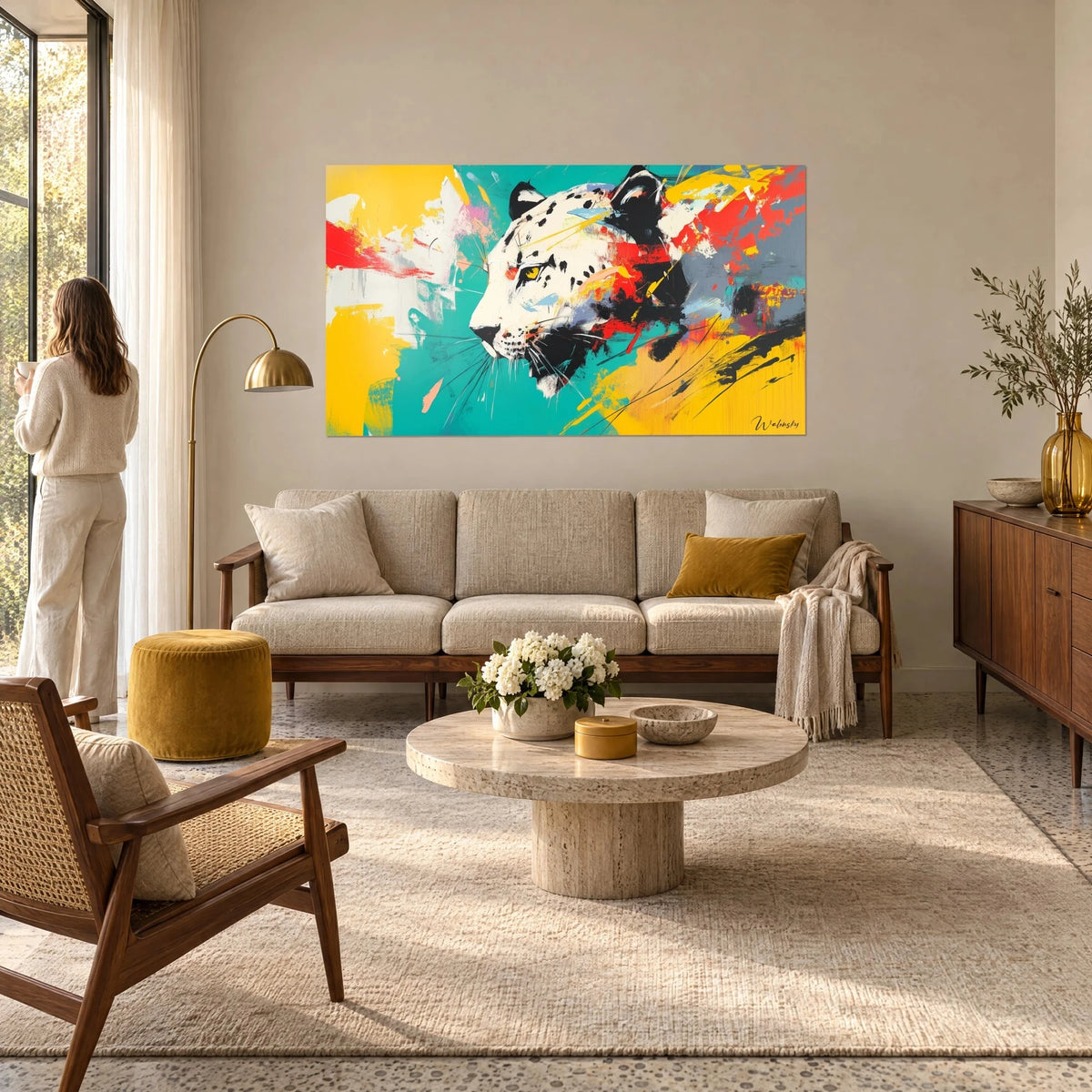 Wall art snow leopard with cream fur spotted in black, turquoise and yellow background, above a sofa in a bright living room