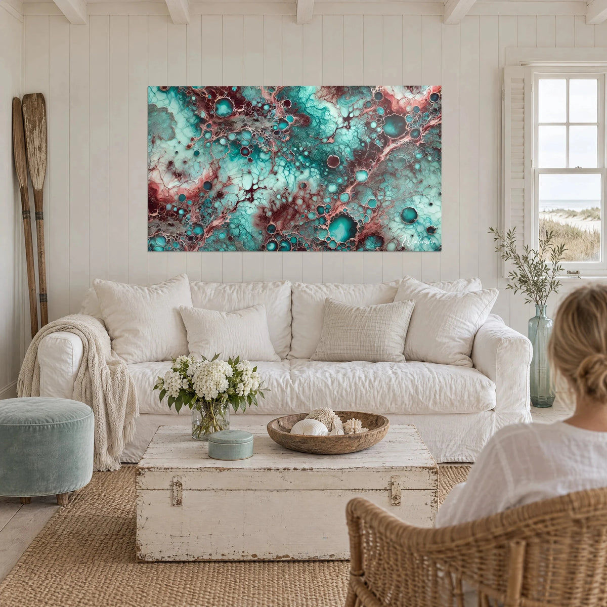 Wall art with fluid turquoise and burgundy patterns, foamy cells, above a sofa in a bright living room