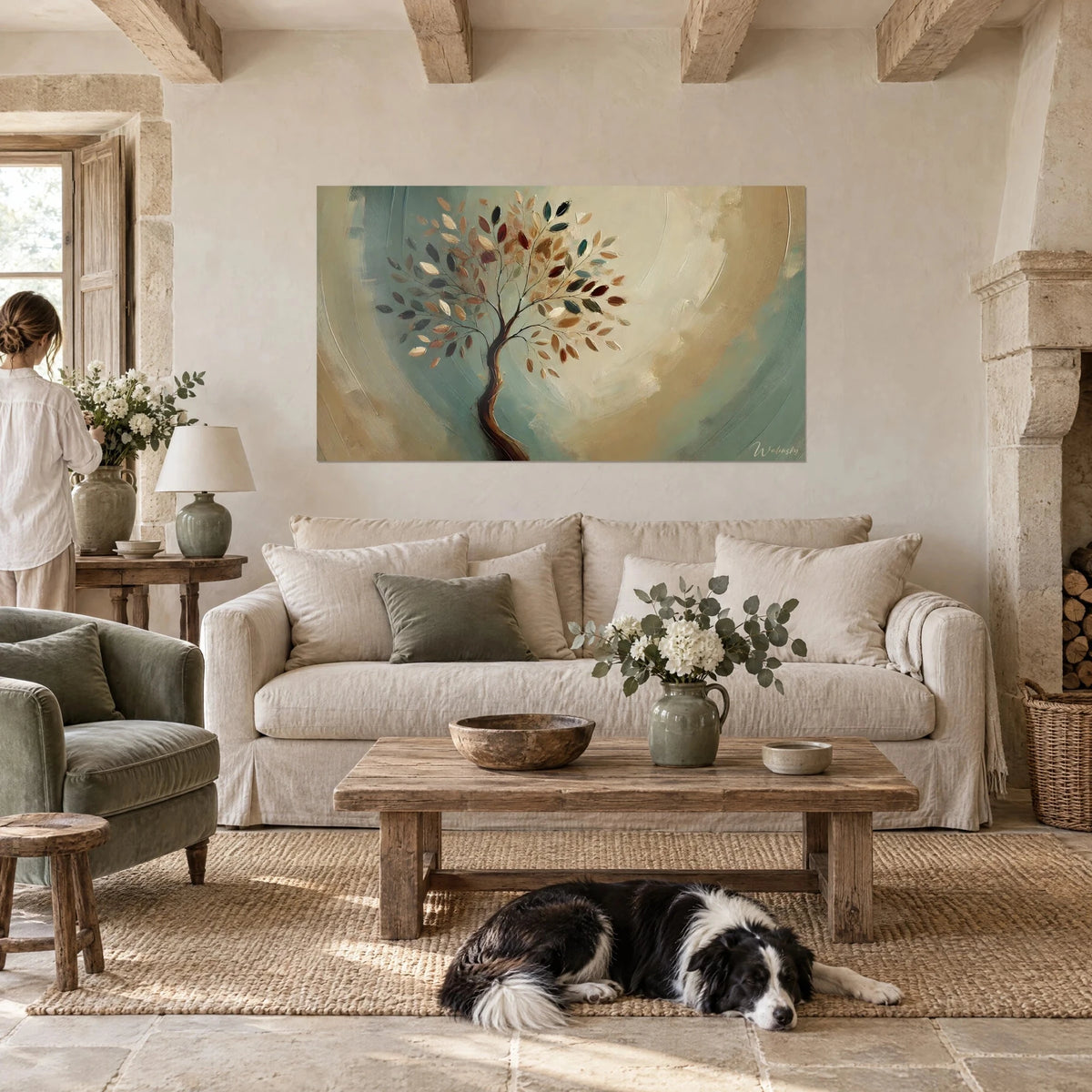 Wall art tree with copper and verdigris leaves on a beige background, facing a person seen from behind and a collie, above a sofa in a bright living room