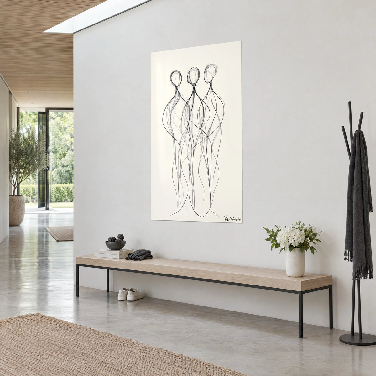 Wall art trio of elongated figures with intertwined black lines on ivory paper, light wooden bench and white vase, sunlit entryway