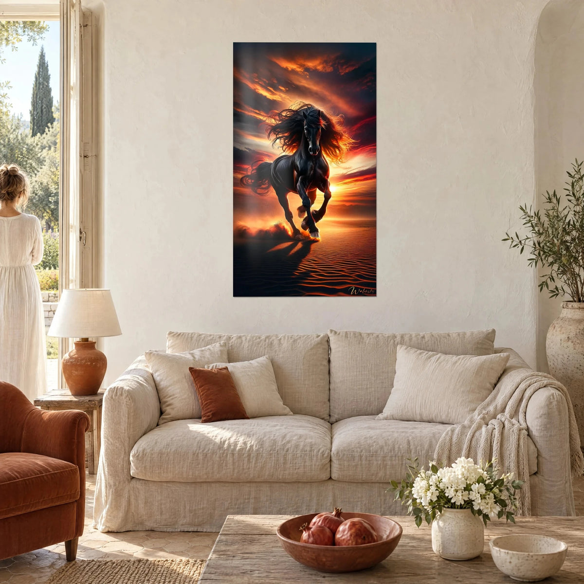 Gemälde Schwarzer Hengst mit wallender Mähne im Galopp unter orangefarbenem und purpurnem Himmel, über einem Sofa in einem hellen Wohnzimmer