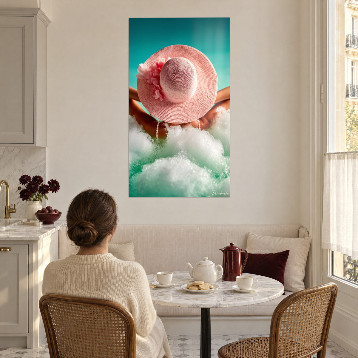 Cuadro bañista de espaldas con sombrero rosa floreado, espuma de baño blanca sobre turquesa, cocina luminosa, mujer sentada a la mesa