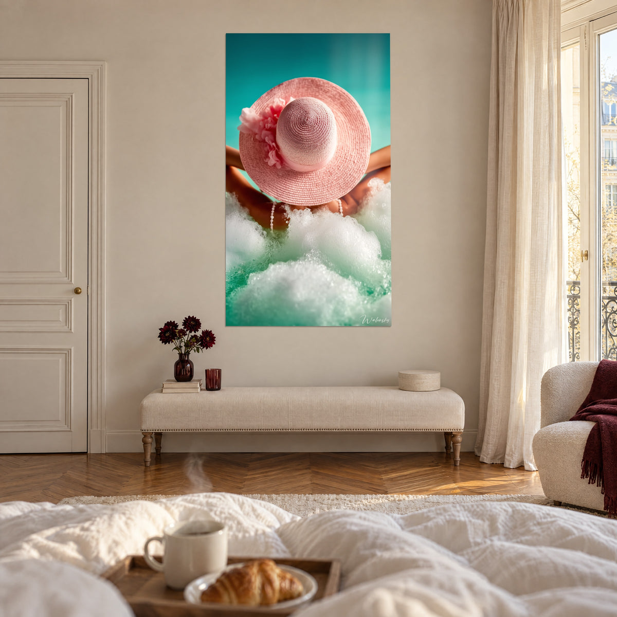 Cuadro gran sombrero de paja rosa suave sobre fondo verde agua, burbujas de espuma, encima de una cama en un dormitorio claro