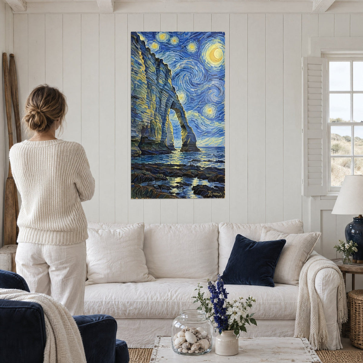 Falaise normande bleu marine et dorée accrochée au-dessus d'un lit dans une chambre claire