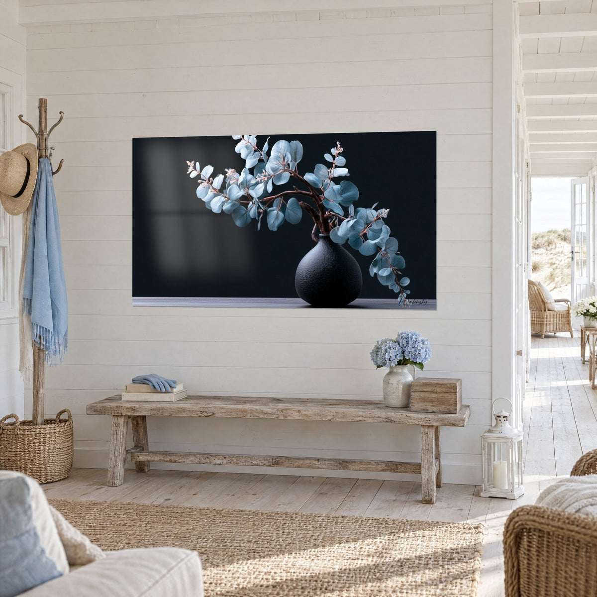 Wall art Silver-toned branch with pink-tinted stems, textured black vase against a dark backdrop, facing a light wood bench in the entryway