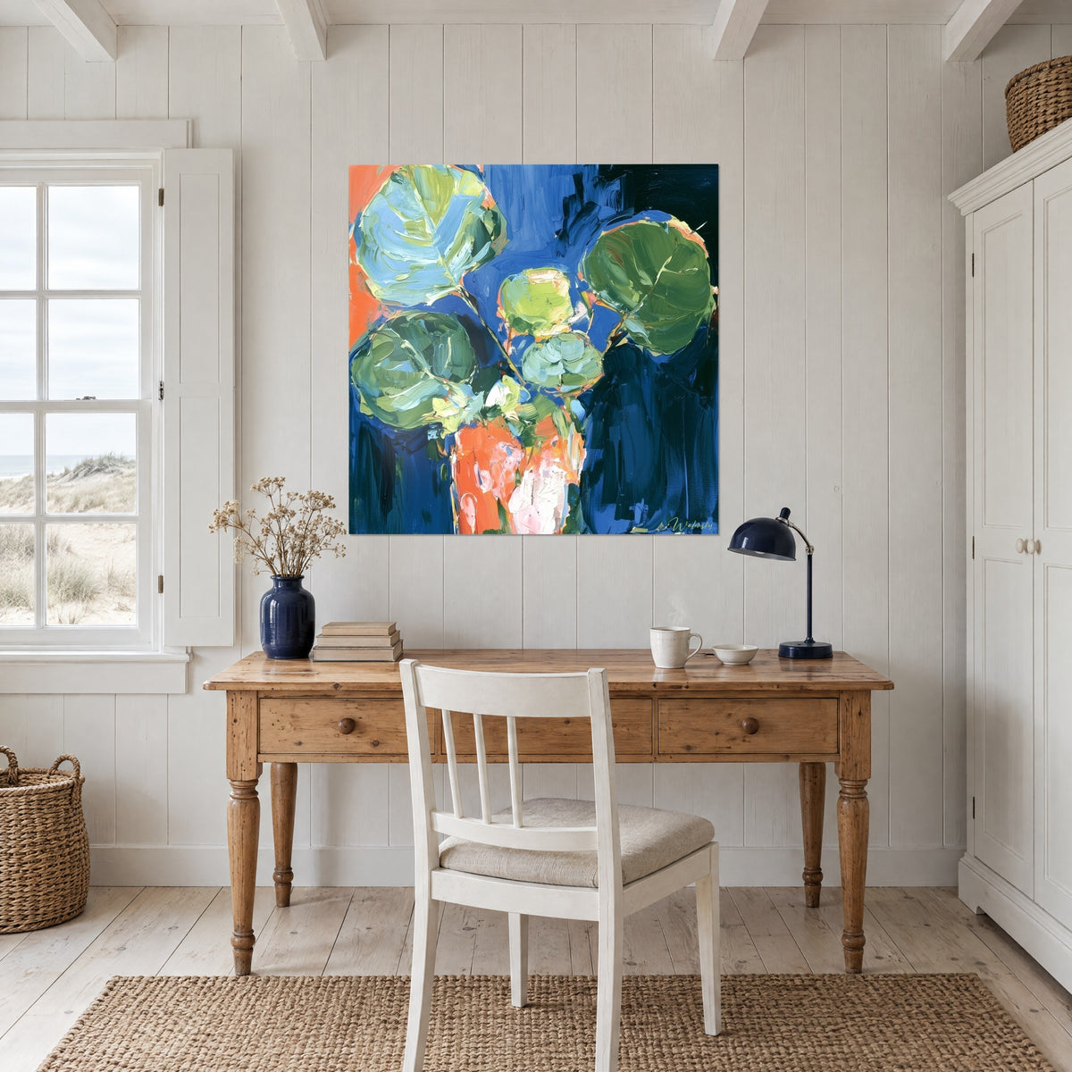 Schilderij levendig eucalyptusboeket, zachtgroene bladeren op koningsblauw, oranje vaas, boven een bureau van licht hout
