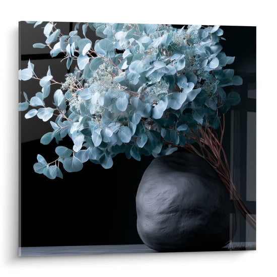 Bouquet d'eucalyptus bleu-gris dans un vase noir texturé sur fond sombre profond