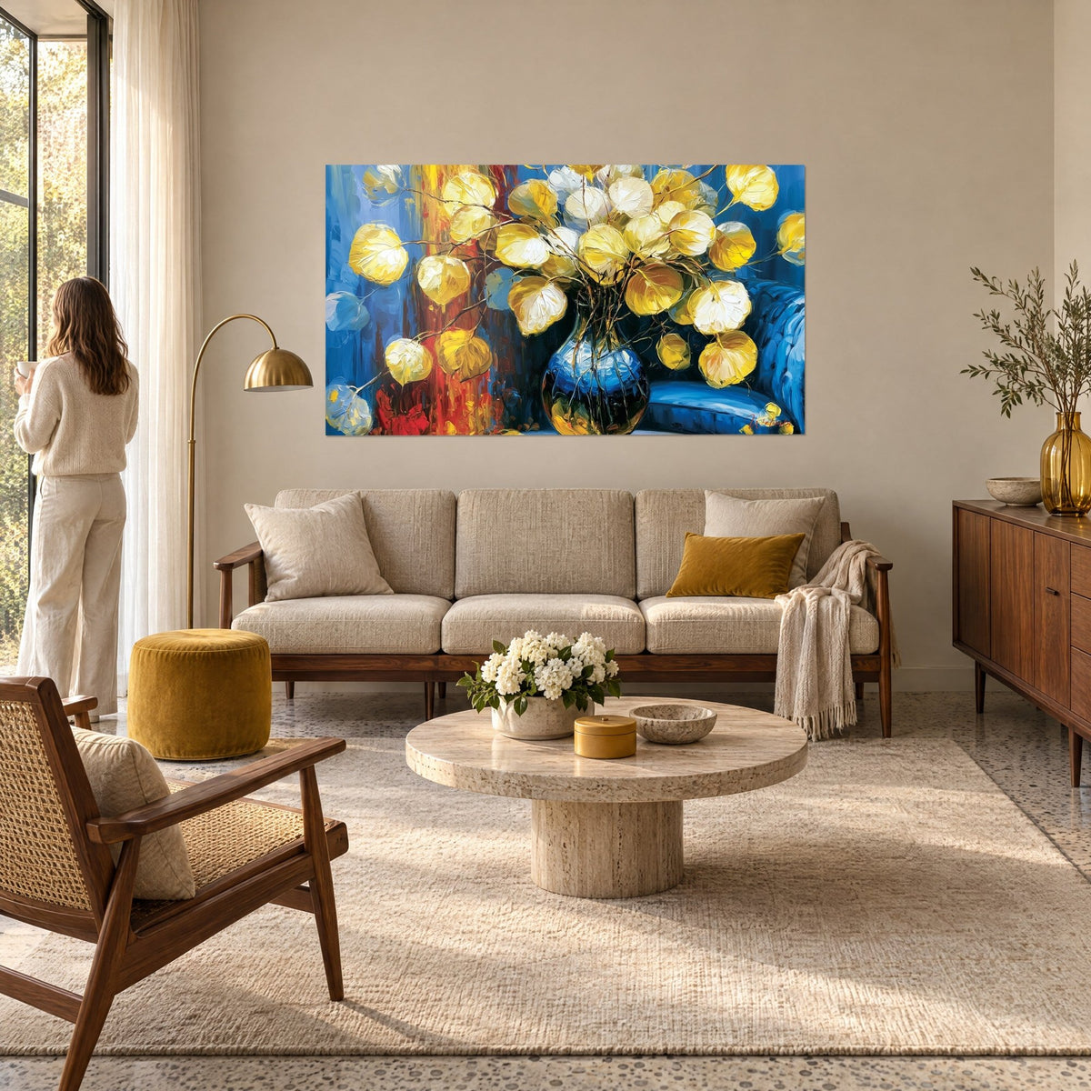 Gemälde Eukalyptusstrauß in Gold in einer blauen Vase, rotorangefarbener Hintergrund, Frau von hinten, über einem Sofa in einem lichtdurchfluteten Wohnzimmer